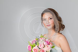 Asian bride standing and holding a bouquet