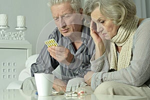 Close up portrait of sick senior man holding inhaler