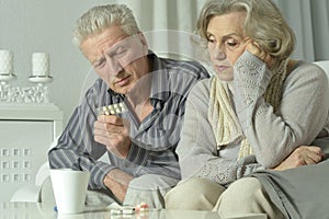 Close up portrait of sick senior man holding inhaler