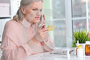 Close up portrait of sick senior woman calling to doctor