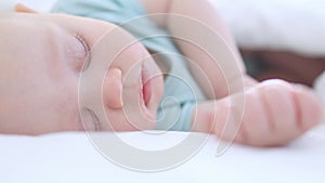 close-up portrait of sleeping infant three months baby in white bedsheets, bed