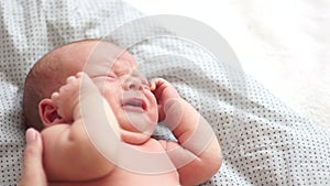 Close-up portrait of a sleeping newborn baby. A serene dream. The child croaks in a dream, crying. Protection of