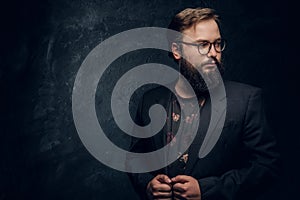 Close-up Portrait of a smart bearded man wearing a black jacket standing in a dark studio