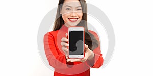 Close up portrait of a smiling asian woman showing blank screen mobile phone while standing isolated over white backgrou photo