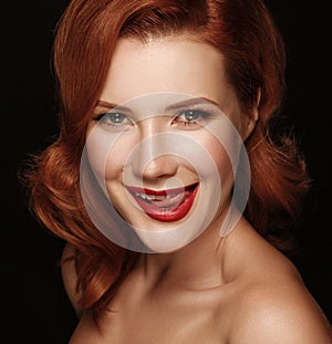 Close-up portrait of a smiling beautiful red-haired girl.