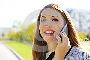 Close up portrait of smiling business woman having a conversation on her cell phone outdoors