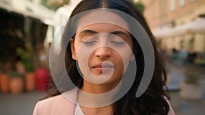 Close up portrait smiling calm young Indian Arabian ethnic woman female girl student businesswoman standing city street