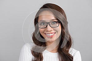 Close up portrait of smiling confident businesswoman looking straight, isolated on grey background.