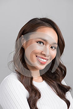 Close up portrait of smiling confident businesswoman looking straight, isolated on grey background.