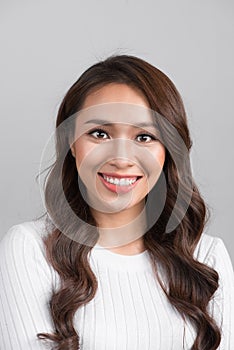 Close up portrait of smiling confident businesswoman looking straight, isolated on grey background.