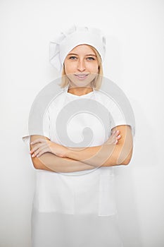 Close up portrait of smiling happy Caucasian young woman, professional confectioner, in white chef's hat and apron