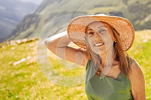 Close up portrait of a smiling happy elderly traveling woman tourist posing against the backdrop of mountains. Old