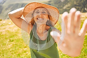 Close up portrait of a smiling happy elderly traveling woman tourist posing against the backdrop of mountains. Old