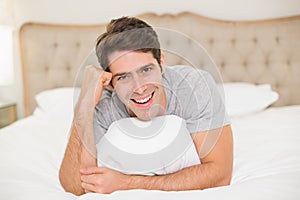 Close up portrait of smiling man resting in bed