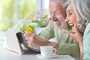 Close-up portrait of a smiling senior couple with newspaper