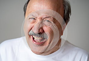 Close up portrait of smiling senior man with happy face looking at the camera