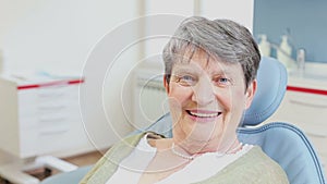 Close up portrait of smiling senior woman sitting in the dental chair