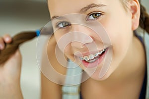 Close up portrait of smiling teenager girl showing dental braces.Isolated on white background.