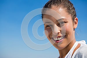 Close up portrait of smiling woman against blue sky