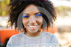 Close up portrait of smiling woman wearing artificial eyelashes