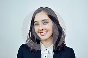 close up portrait of a smiling young businesswoman wearing black jacket on a white background