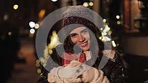 Close up Portrait of Smiling Young Charming Girl, Looking Happy, Holding Gift Box, Standing in Falling Snow Outdoor
