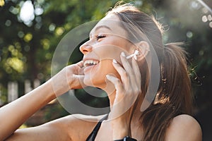 Close up portrait of a smiling young fitness girl listening