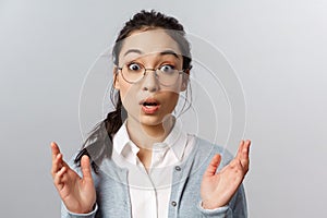 Close-up portrait of startled and amazed asian female coworker, office employee heard astounding rumor, clasp hands