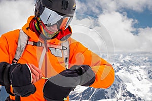 Close-up Portrait of a stern climber skier in sunglasses and a cap with a ski mask on his face. against the backdrop of