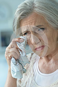 Close-up portrait of stressed senior woman crying