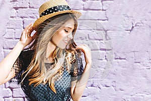 Close-up portrait of stunning blonde girl with hair waving posing with eyes closed and cute smile. Aorable young woman