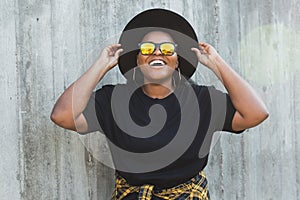 Close-up portrait of stylish young African American girl with curly hair in fashionable sunglasses in urban - summer