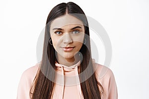 Close up portrait of stylish young modern woman with natural light make up, smiling at camera and look confident