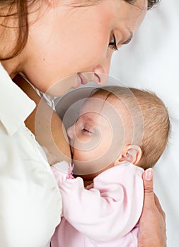 Close-up portrait of suckling baby infant and mom