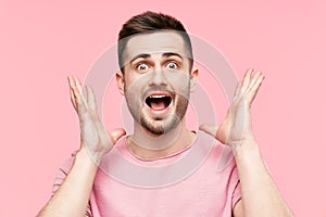 Close up portrait of surprised and amazed man with arms raised