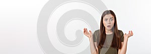 Close-up portrait of surprised beautiful girl holding her head in amazement and open-mouthed. Over white background