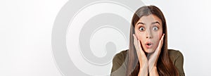 Close-up portrait of surprised beautiful girl holding her head in amazement and open-mouthed. Over white background