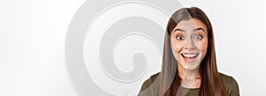 Close-up portrait of surprised beautiful girl holding her head in amazement and open-mouthed. Over white background