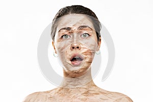 Close-up portrait of a surprised beautiful woman with large wrinkles on her face and dry skin. Isolated on a white background. The