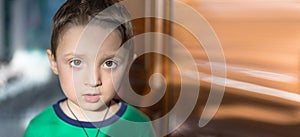 Close up portrait of a surprised european baby boy looking at camera over light background