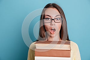Close-up portrait of a surprised woman holding books