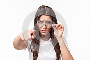 Close-up portrait of suspicious, judgemental woman in glasses, blame someone, frowning, squinting at person who she