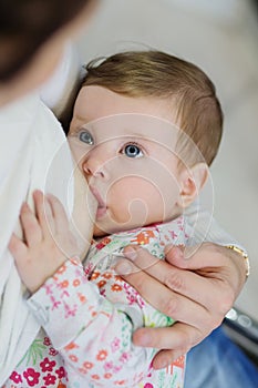 Close-up portrait of sweet newborn baby breastfeeding