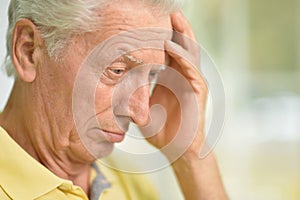 Close up portrait of thoughtful senior man at home