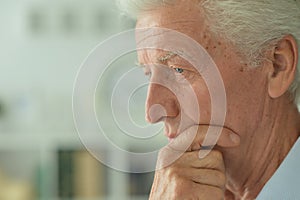Close up portrait of thoughtful senior man at home