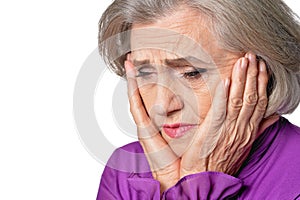 Close up portrait of thoughtful senior woman with headache on white background