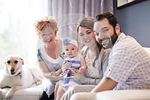 Close up portrait of three generations of women being close, grandmother, mother and baby daughter at home