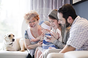 Close up portrait of three generations of women being close, grandmother, mother and baby daughter at home