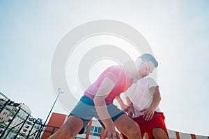 Close up portrait of two basketball players while the push each other for ball possession