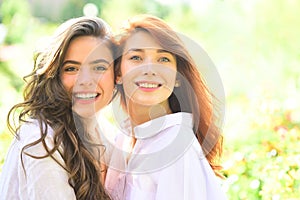Close up portrait of two beautiful young girls with clear fresh young face skin and perfect nude makeup.
